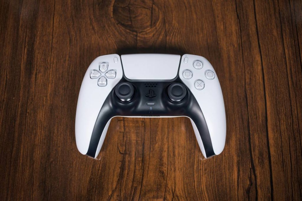 White Dualsense Controller on a woody brown background mid-distance